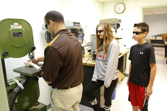        ROBERT K. YOSAY  | THE VINDICATOR..Mike Donatelli -  uses a band saw to cut out his students designs  as Elizabeth Dragus and Anthony Colarossi look on.....STEM students use computers, drawing programs, and study aerodynamics as part of the STEM program...-30-