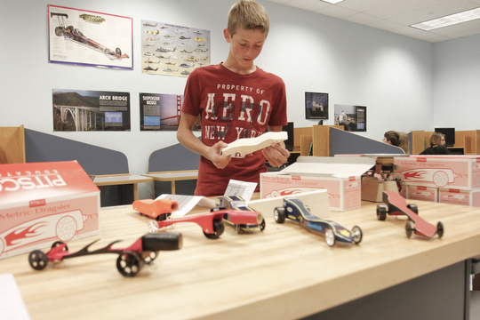        ROBERT K. YOSAY  | THE VINDICATOR..Tyler Razo 8th grade...  works on his CO2 car after designing it and having its shape cut for him.  STEM students use computers, drawing programs, and study aerodynamics as part of the STEM program. The cars in front our prior years cars....-30-