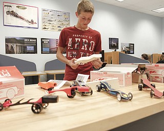        ROBERT K. YOSAY  | THE VINDICATOR..Tyler Razo 8th grade...  works on his CO2 car after designing it and having its shape cut for him.  STEM students use computers, drawing programs, and study aerodynamics as part of the STEM program. The cars in front our prior years cars....-30-