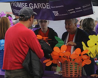 Carrie Mitchell (right) of Youngstown gives a pin-wheel flower to Bonito Velazques Jr. of Youngstown during the Walk to End Alzheimers at the Watson and Tressel Training Site on Saturday morning.   Dustin Livesay  |  The Vindicator  10/11/14  WATTS, YSU
