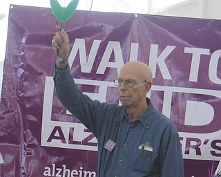 Christopher King of Sebring holds up the blue flower to indicate that he is currently suffering from Alzheimers during the Walk to End Alzheimers at the Watson and Tressel Training Site on Saturday morning.   Dustin Livesay  |  The Vindicator  10/11/14  WATTS, YSU