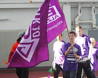 Hunter Schwab (14) of Canfield carries a "Walk to End Alzheimers" flag at the front of the pack while walking around the WATTS at YSU during the Walk to End Alzheimers on Saturday morning.   Dustin Livesay  |  The Vindicator  10/11/14  WATTS, YSU