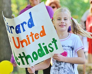 Jeff Lange | The Vindicator  Casey Brookbank smiles as she holds a sign for her church as she participates in the CROP Walk, Sunday afternoon in Youngstown.
