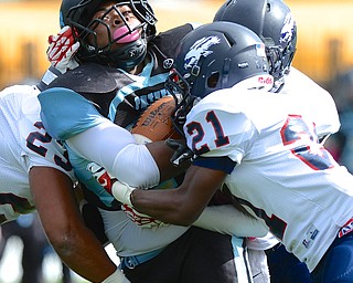 Jeff Lange | The Vindicator  East's Damon Green is crunched in between Dwayne Howell (21) and Damien Gray (23) of Fitch during his run for yards in the first quarter, Saturday afternoon at Rayen Stadium.