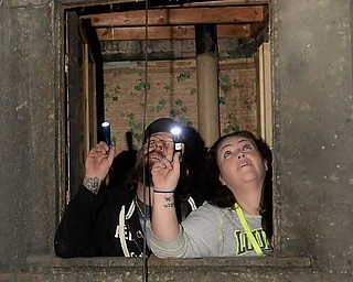 Jeff Lange | The Vindicator  Couple from Newton Falls Thomas Hull (left) and Melissa Sanderbeck (right) peer out of a window inside of the J.C. Thompson Building in East Liverpool, Saturday, Oct. 11th.