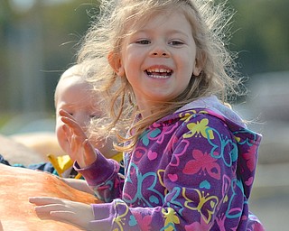 Jeff Lange | The Vindicator  Aurora Nessle (4) of Boardman plays on a pumpkin, Saturday afternoon during the lunch break of the 20th annual Giant Pumpkin Weigh-Off at Parks Garden Center. Aurora is the daughter of Jessica Nessle.