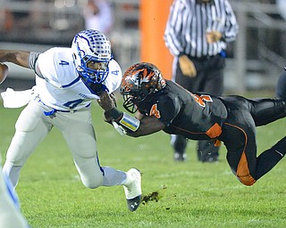Jeff Lange | The Vindicator  Hubbard running back George Hill is brought down by Howland defender Jaquoire Marrs (diving) as he runs for a small gain during first quarter action in Howland, Friday evening.