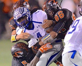 Jeff Lange | The Vindicator  Hubbard's George Hill (4) is brought down by Howland's Ameer Williamson (5) and Austin Baker (86) during a run in the first quarter of their Friday night matchup in Howland.