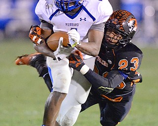 Jeff Lange | The Vindicator  Hubbard running back George Hill (4) runs as he's tackled from behind by Howland's Steve Baugh (23) during third quarter action in Howland, Friday night.