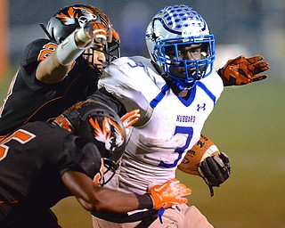 Jeff Lange | The Vindicator  Hubbard running back Larry Scott (3) is tackled by Howland's Steve Baugh (back left) and Ameer Williamson (front left) during third quarter action, Friday night in Howland.