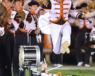 Jeff Lange | The Vindicator  Howland's Nolan Nadler (in air) hurdles drumline captain Jordan Mirto as the band takes the field for their halftime performance, Friday night in Howland.