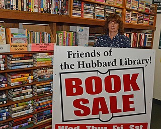 Katie Rickman | The Vindicator.Bonnie Viele, treasurer of Friends of the Library stands behind the sign that will hang in front of Hubbard Library during the book sale Oct. 22-Oct. 25, 2014. Viele along with many Friends of the Library volunteers meet Thursday mornings to sort through thousands of donated books at the Hubbard Public Library.