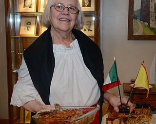 Katie Rickman | The Vindicator.Helen LoSasso of Boardman  holds a traditional Italian dish of sausage and peppers while holding flags representing Italy and Sicily because both nationalities play a part in her international meal that she will prepare for the international dinner at Bethel Lutheran Church on October 25, 2014.