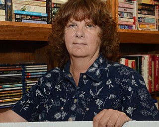 Katie Rickman | The Vindicator.Bonnie Viele, treasurer of Friends of the Library stands behind the sign that will hang in front of Hubbard Library during the book sale Oct. 22-Oct. 25, 2014. Viele along with many Friends of the Library volunteers meet Thursday mornings to sort through thousands of donated books at the Hubbard Public Library.