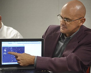 Katie Rickman | The Vindicator.Keith Brooks, Senior Vice President OEM Sales at altronic Hoerbiger Engine Solutions in Girard points to a satellite photograph of an oil field in North Dakota on Thursday, Oct. 16, 2014 at the Girard facility.  The bright spot shows the light from  "flaring" taking place at the oil cite to burn off natural gas.