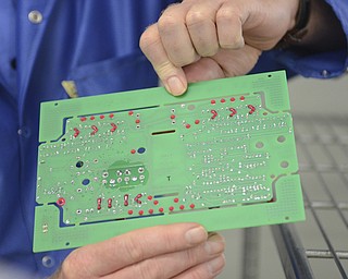 Katie Rickman | The Vindicator.Doug Cirbus, Vice President of Operations at altronic Hoerbiger Engine Solutions holds up a circuit board at the Girard facility on Thursday, Oct. 16, 2014.
