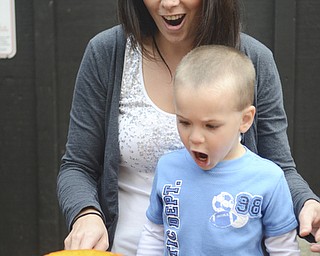 Katie Rickman | The Vindicator.Mallori DuVall of Austintown carves a pumpkin with her son Maxwell, 2, they mimic the expression of the pumpkin as Maxwell lets out a roar on Thursday, Oct. 16, 2014.