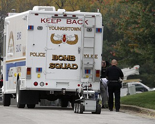        ROBERT K. YOSAY  | THE VINDICATOR..The Bombs Squad remote vehicle works the area where the bomb was noticed.( it was between the bushes)..The Youngstown Police Dept  bomb squad set off what appeared to be a pipe bomb outside a broken window at the Betras, Harshman and Kopp law office in Canfield on Seville Dr...that ended up not being explosive....-30-