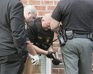       ROBERT K. YOSAY  | THE VINDICATOR..Sgt. larry McLauglin inspects the bomb-  as Youngstown Police Dept Bomb Squad and Mahoning County Sheriffs Dept .. investigate the area where the supposed pipe bomb was detonated...The Youngstown Police Dept  bomb squad set off what appeared to be a pipe bomb outside a broken window at the Betras, Harshman and Kopp law office in Canfield on Seville Dr...that ended up not being explosive....-30-