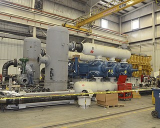 Katie Rickman | The Vindicator.A 5,000 horsepower caterpillar engine, far right, will power the compressor, in middle, which is assembled at Dearing Compressor and Pump Company in Youngstown on Friday, Oct. 17, 2014. The machinery is pieced together at the shop and then taken apart before being shipped and will be reassembled once it reaches its destination.