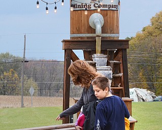 Katie Rickman | The Vindicator.There are many attractions at the Maze Craze including the “Mining Company” where maize participants can purchase a “Discovery Mix Bag” and mine the various products (pay dirt, synthetic arrowheads, fossils, or sand with gems) Brenda Lattanzio points out various items to her son Vincent, 9, and her daughter Gia,11, on Friday, September 17, 2014.