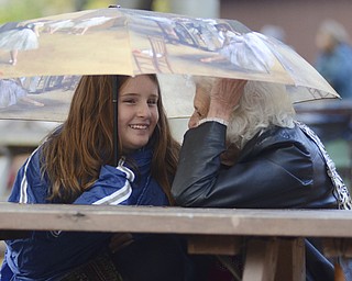 Katie Rickman | The Vindicator.Matilda Reed, 11, smiles as she huddles under an umbrella with her great-grandma in attempts to stay dry and warm during the chilly day at Christmas in the Woods in Columbiana on Saturday, Oct. 18, 2014.