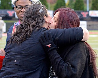 Jeff Lange | The Vindicator  Senior General Studies major, Rebecca Banks (right) kisses 2013's homecoming queen Melissa Wasser after she was declared the YSU homecoming queen of 2014, Saturday evening during Youngstown's halftime.