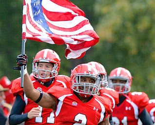 Jeff Lange | The Vindicator  Christian Bryan (2) of YSU leads the Penguins onto the field as he carries the American Flag during the pregame announcements, Saturday night at Stambaugh Stadium. The Penguins went on to oust the Salukis in a 26-14 victory.