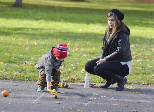 Katie Rickman | The Vindicator.Katerina Mallias of Campbell watches over her cousin Yianni Koullias, 4, as he plays tic-tac-toe with pumpkins and gourdes at the Fall Festival hosted by Campbell Pride at Roosevelt Park in Campbell on Sunday, Oct. 19, 2014.