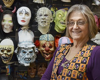 Katie Rickman | The Vindicator.Shirley James, owner of Ward Costumes Shoppe in Niles poses for a photo in front a wall full of masks in the shop on Monday, Oct. 20, 2014.