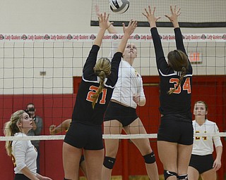 Katie Rickman | The Vindicator.Mooney's Autumn Desantis hits the ball over the net as Mineral Ridge's Alyssa Harkins (21) and Anna Bodo attempt to block her during the fourth period of the district semi final at Salem  High School on Wednesday, Oct. 22, 2014.