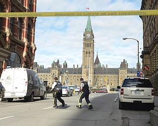 Police secure the scene of a shooting on Parliament Hill in Ottawa on Wednesday. A soldier standing guard at the National War Memorial was shot by an unknown gunman, and gunfire rang out inside the halls of Parliament.