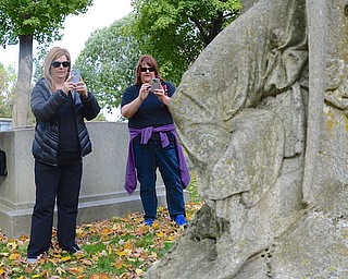 Jeff Lange | The Vindicator  Jean Walk of Liberty (left), Pattie Conti of Canfield (center) and Karen Orlando of Girard (right) stop to photograph a gravestone in the Oak Hill Cemetery during a tour, Saturday afternoon.