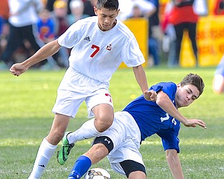 Jeff Lange | The Vindicator  Mooney's Michael Myers (7) trips as Poland's Joseph Shields slides to steal the ball away during second half tournament action in Struthers, Saturday afternoon.