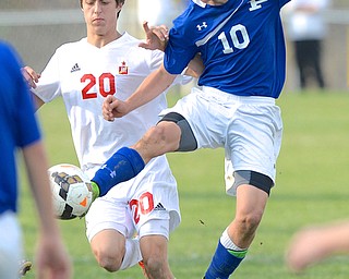 Jeff Lange | The Vindicator  Poland's Anthony Sabula (10) jumps to kick the ball in front of Mooney's Christopher Perry (20) during second half tournament action in Struthers, Saturday afternoon.