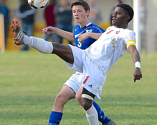 Jeff Lange | The Vindicator  Mooney's Myles Harris (front) kicks the ball over his head as Poland's Evan Rumble watches from behind, Saturday afternoon during tournament action in Struthers.
