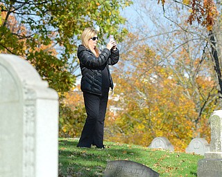 Jeff Lange | The Vindicator  Pattie Conti of Canfield stops to photograph the view from atop of the hill by the Henry Wick Cross, Saturday afternoon during the guided tours of the Oak Hill Cemetery.