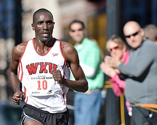 Jeff Lange | The Vindicator  Patrick Cheptoek (10) of Bowling Green pushes on in the homestretch of the 10K Peace Race as fans cheer him on from behind, Sunday in Youngstown.