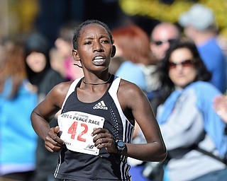 Jeff Lange | The Vindicator  Mary Wangeci (42) of Lansing Michigan runs to the finish line during the Peace Race 10K in Youngstown, Sunday morning. Wangeci was the first female runner to cross the finish.
