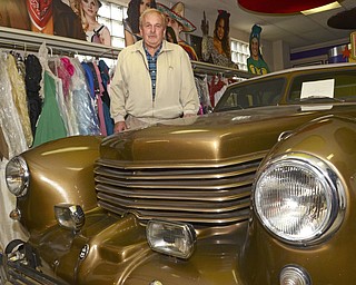 Katie Rickman | The Rickman .Quinton Hoover, owner of Quincy's Costumes in Youngstown poses next to his 1964 Cord that is parked inside the costume shop on Tuesday, Oct. 21, 2014.