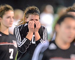 Jeff Lange | The Vindicator  Canfield senior team captain Sydney Miller (center) cries into her hands as her and the rest of the Cardinals walk off the field after suffering a 1-0 loss in overtime to Lake Catholic, Tuesday night at Brush High School.