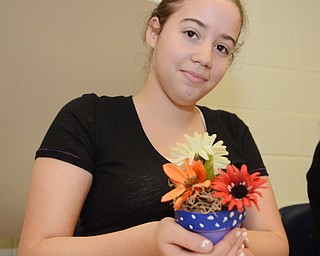 Katie Rickman | The Vindicator .Melanie Paez, 13, of Liberty holds up  a pot that she made at the Akiva Academy on Thursday, Oct. 23, 2014. The Students will distribute the decorative pots on on Mitvah Day.