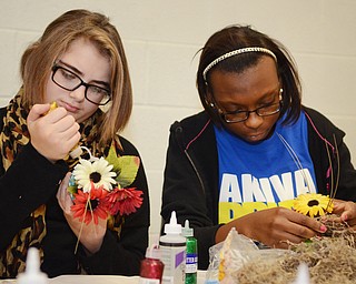 Katie Rickman | The Vindicator .Madlyn Hudak, 13, of Girard, on left, works alongside Faith Johnson, 15, of Youngstown decorating pots that they made at the Akiva Academy on Thursday, Oct. 23, 2014. The Students will distribute the decorative pots on on Mitvah Day.