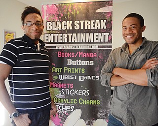 Katie Rickman | The Vindicator .Justin, left and Terry Raimey pose for a photo in the Youngstown home with a sign promoting their business, Black Street Entertainment Oct. 23, 2014. The brothers started the business three years ago and have seen success..