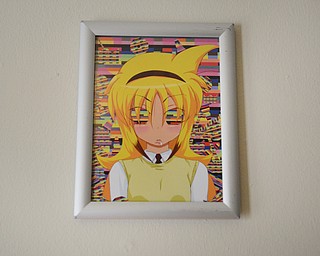 Katie Rickman | The Vindicator .Artwork hangs on a wall in the home of Justin and Terry Raimey's home where the brother's business, Black Street Entertainment is run out of.  Stickers, books, buttons, and patches are among the many items made by the company.