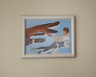 Katie Rickman | The Vindicator .Artwork hangs on a wall in the home of Justin and Terry Raimey's home where the brother's business, Black Street Entertainment is run out of.  Stickers, books, buttons, and patches are among the many items made by the company.