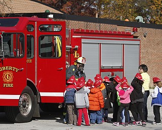        ROBERT K. YOSAY  | THE VINDICATOR..Students listen to Capt Bob Catchpole... as he explains the FD fire truck..Kindergarten students from  E J BLOTT in Liberty head out with red fire hats from Gibson Insurance who sponsored the event with the Red Cross and  Liberty FD ...-30-