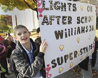 William D. Lewis The Vindicator Williamson 6th grader Armando Hernandez carries a sign during a parade along Wood St. during a Thursday 10242014 parade promoting after school activities.