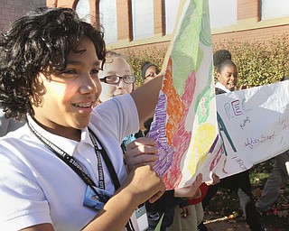 William D. Lewis The Vindicator Rayen early college 7th grade Altonio Clark carries a banner during a Thursday 10242014 parade promoting after school activiites.