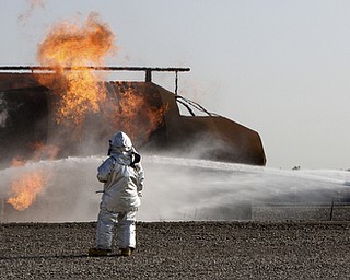William D Lewis the Vindicator  Firefighter extinguish a blaze after a mock plane crash at Youngstown Air Force Reserve Base Monday 10-27-14. Base firefighter along firefighters from area departmentw and The Red Cross participated in the event.